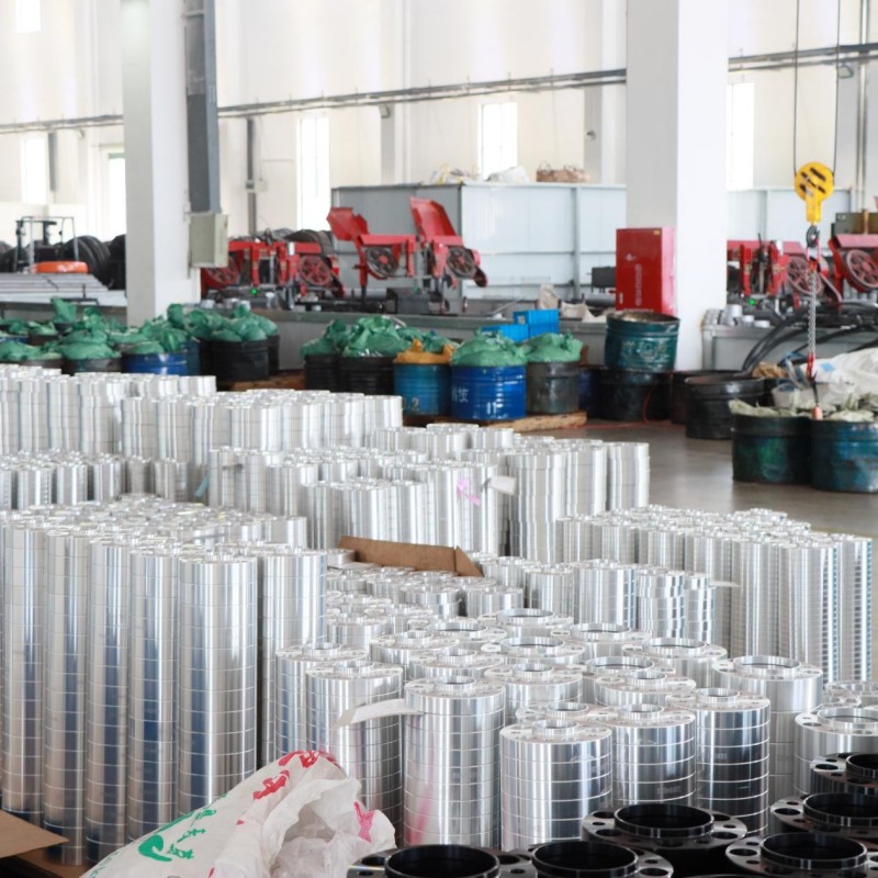 J&W production area with rows of machined cylindrical parts and black wheel spacers