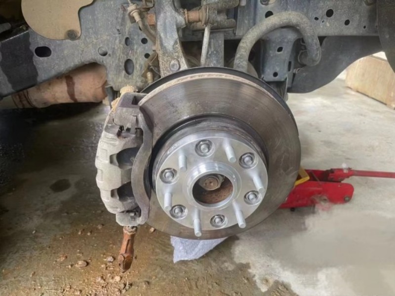Silver bolt-on spacer installed on a hub with wheel-side studs